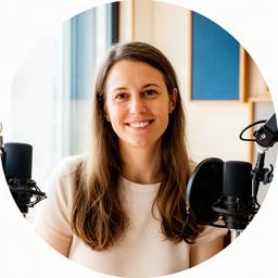 Nancy Ratter, lead podcast producer, seated beside microphones in a bright studio